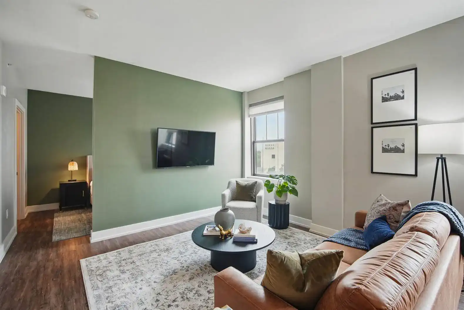 Modern open-concept living space featuring a warm leather sofa, plush textures, and a smart TV—perfect for relaxing or streaming your favorites.