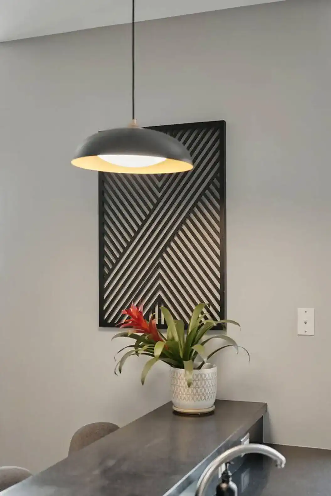 Modern pendant light and geometric wall art add a bold, designer feel to the space. Brighten up your mornings with a fresh flower touch at the bar.