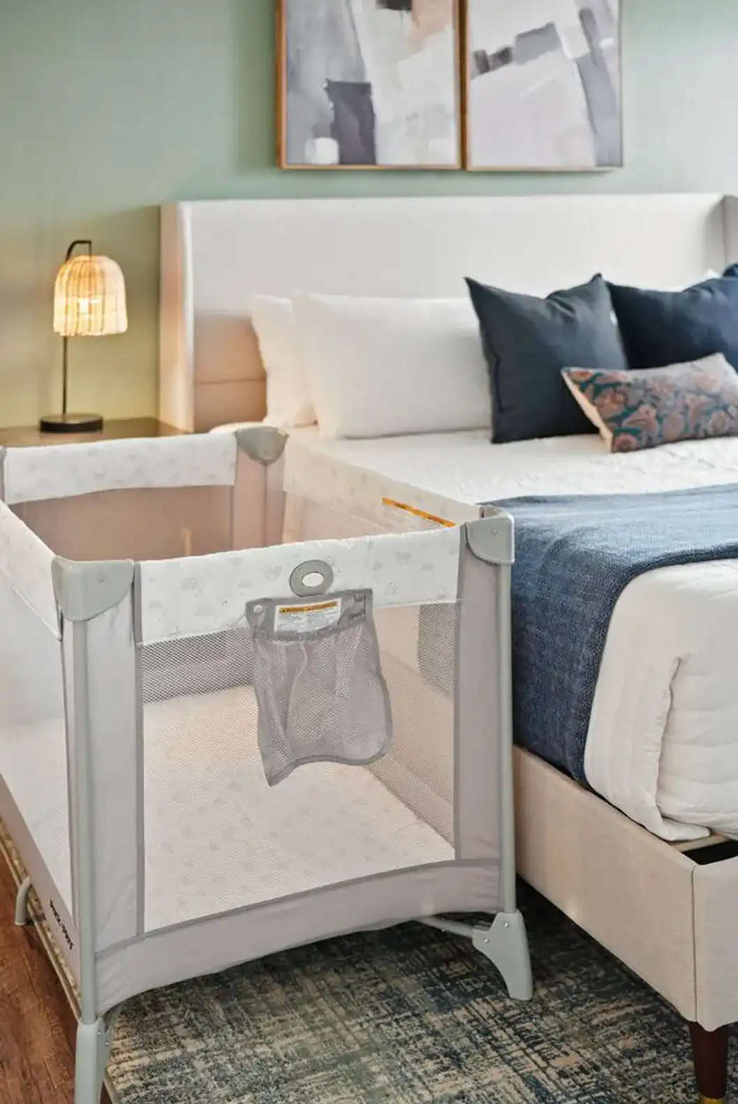 Alternate angle of the Pack ‘n Play, showcasing its proximity to the bed and stylish setup—making family travel stress-free.