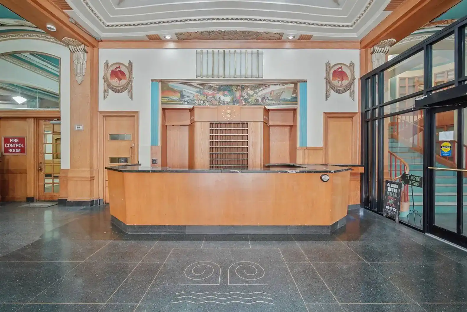 A nod to the past—this original check-in counter sits under hand-painted murals and detailed ceiling art.