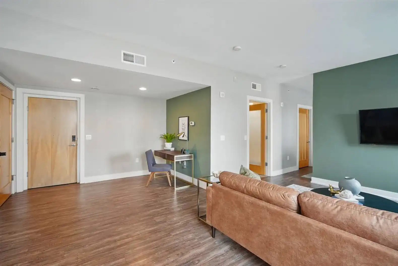 Thoughtfully curated workspace includes a sound speaker, plant decor, and reminders for a clean, comfortable stay.
