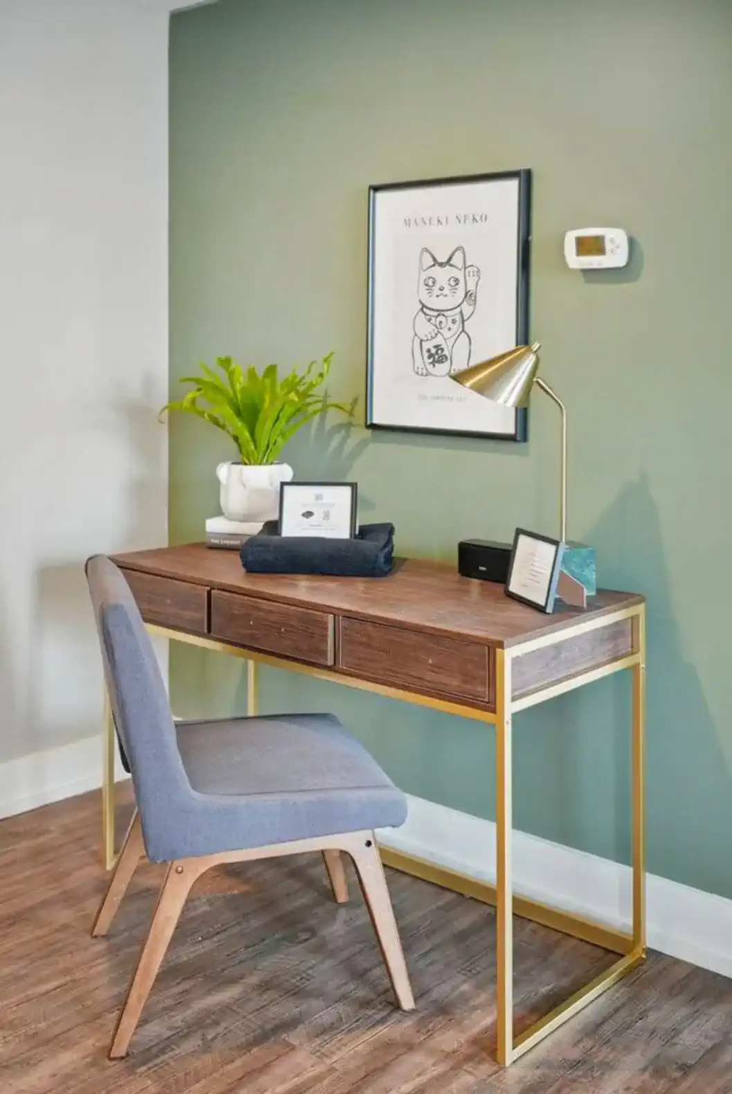 Need to get things done? A stylish desk with gold accents, comfy chair, and task lighting provides a quiet, productive nook.