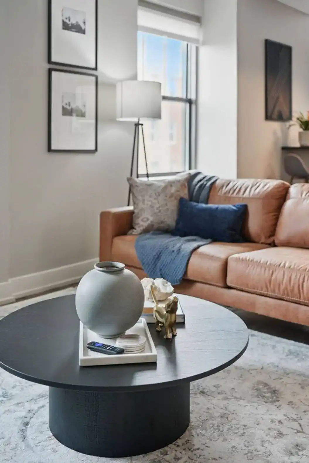 Lounge on a rich leather couch with designer pillows, cozy throws, and curated coffee table decor for a luxe yet inviting vibe.