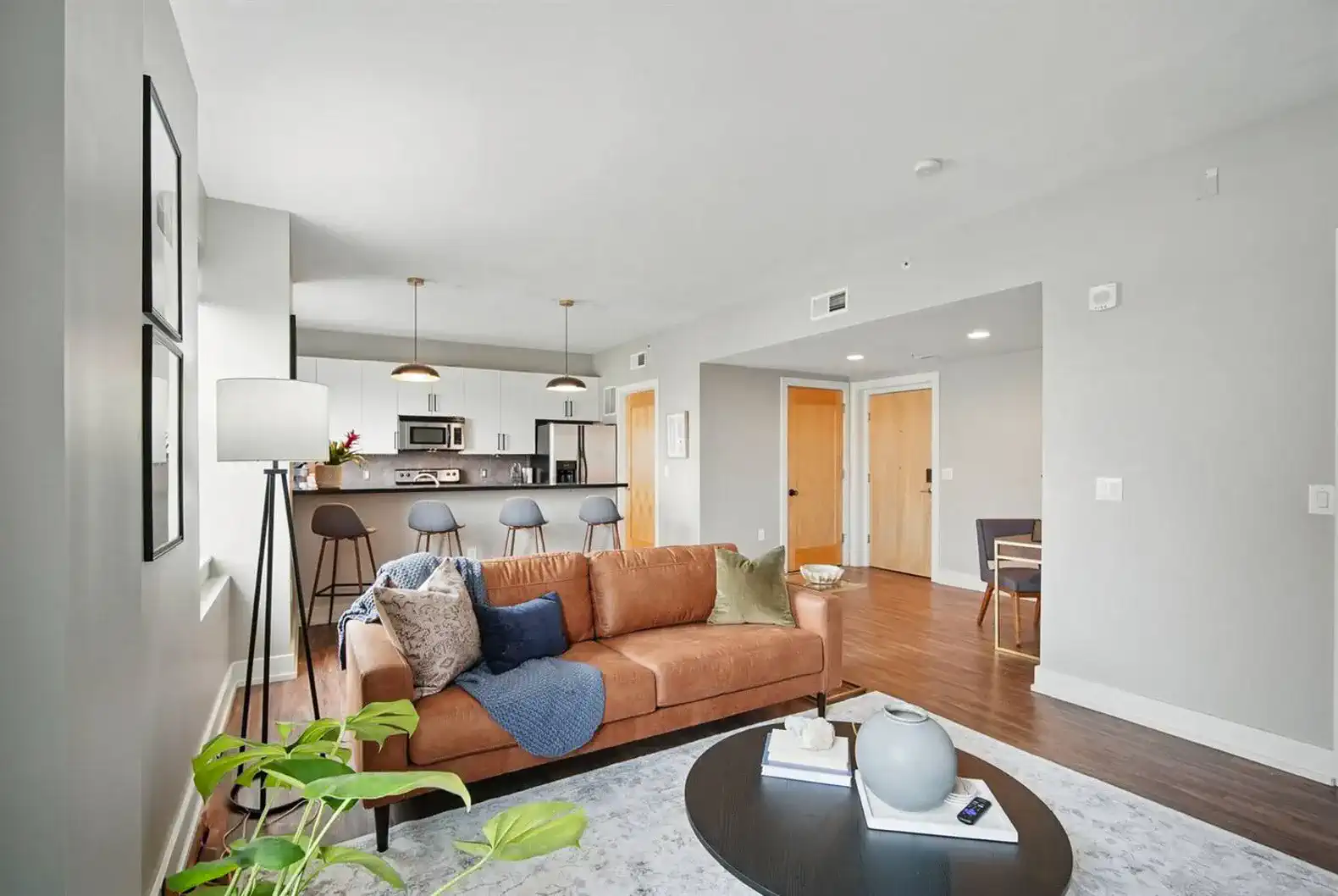 Open-concept living and kitchen area with tons of natural light, a leather sofa, and modern finishes—ideal for relaxing or entertaining.