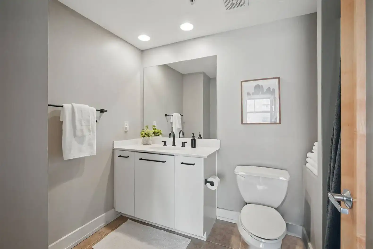 Bright, clean bathroom with a large mirror, soft lighting, and modern fixtures. Includes plush towels, essential toiletries, and thoughtful design for a relaxing start and end to your day.
