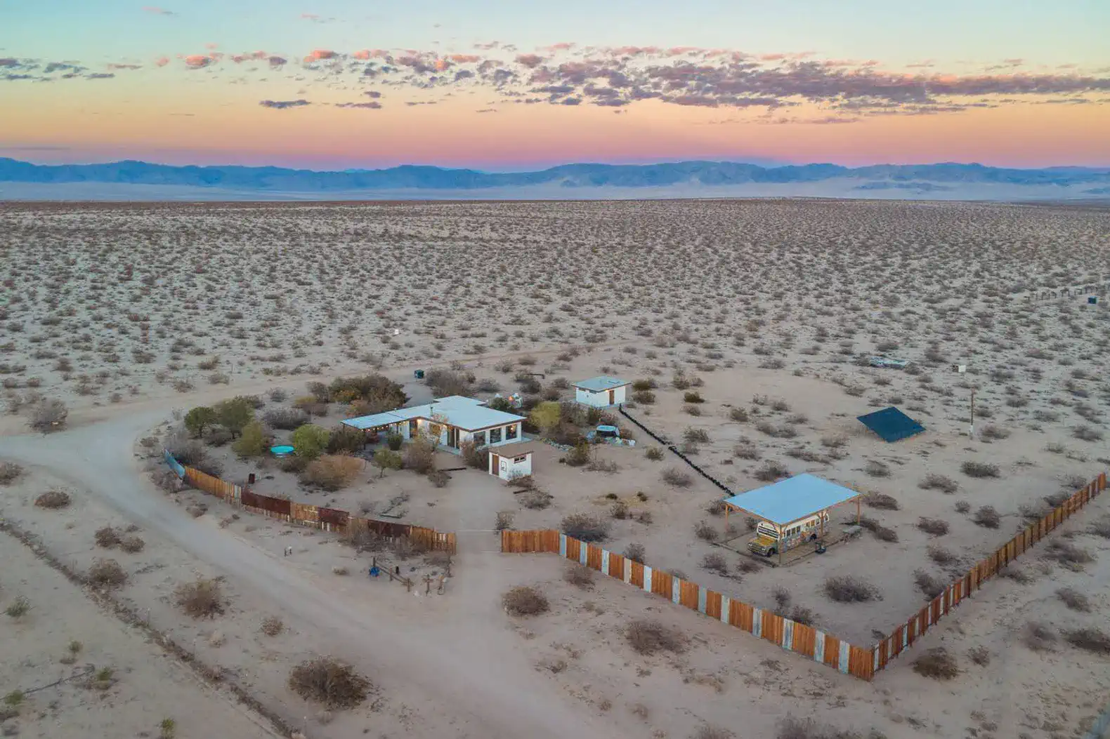Aerial view of Desert's Edge surrounded by desert landscape and mountains in the distance