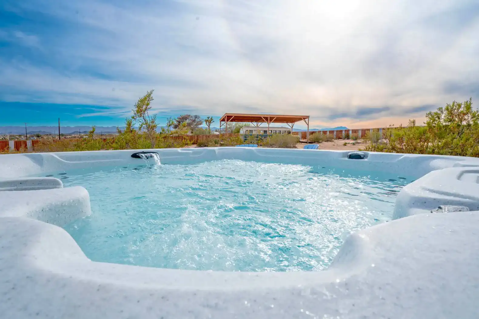 Hot tub with clear water and scenic desert landscape in the background