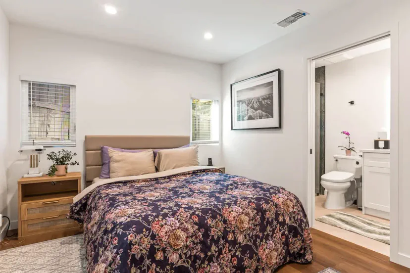 Primary ensuite bedroom with smart tv, dresser, closet