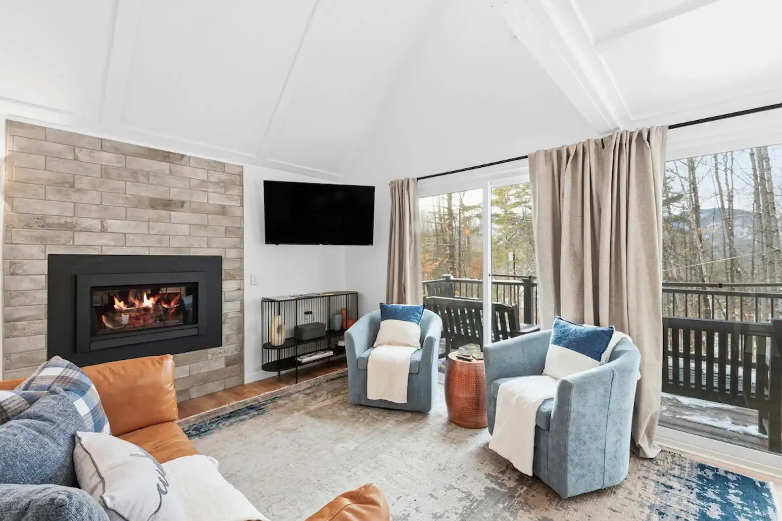 Cozy living area with a fireplace and large windows overlooking the trees