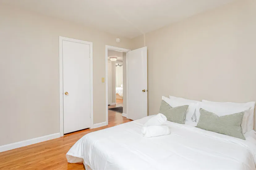 Cozy bedroom with a queen bed, soft linens, and natural light from the doorway