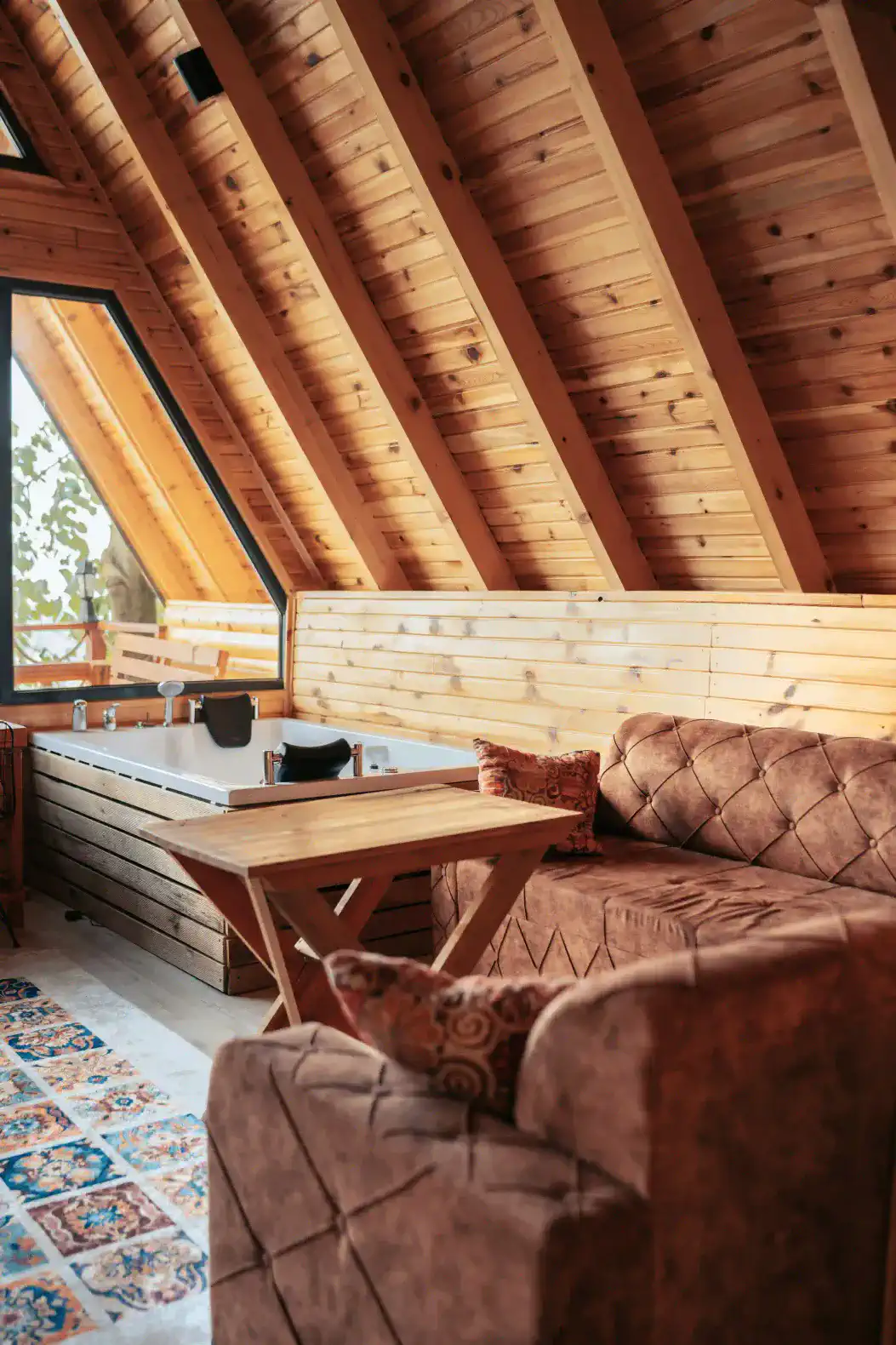 Cozy living area with wooden beams, plush seating, and a view of the outdoors