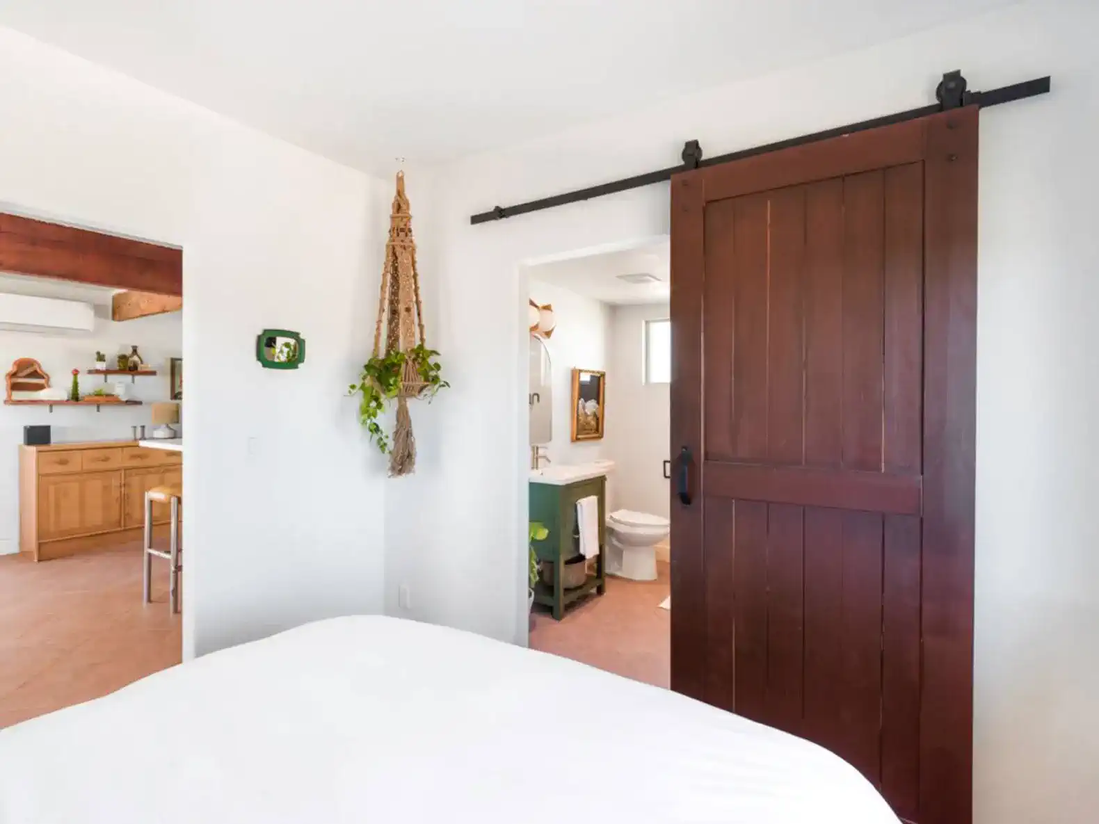 Cozy master bedroom with sliding barn door leading to a bathroom