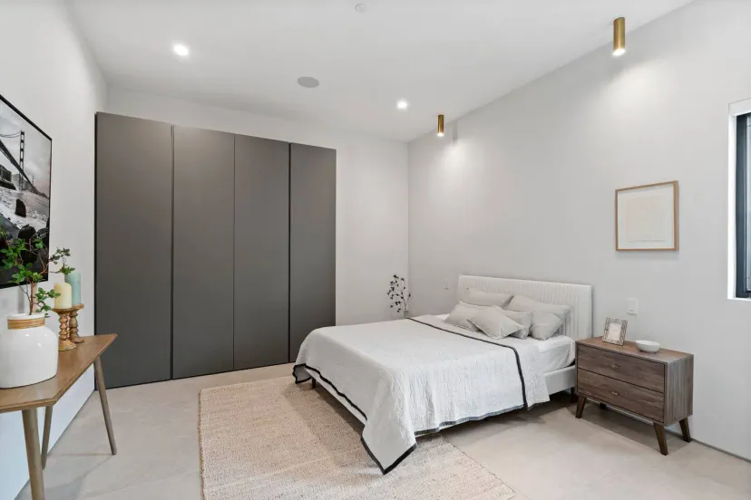 Dormitorio moderno con cama queen, decoración minimalista y armario empotrado