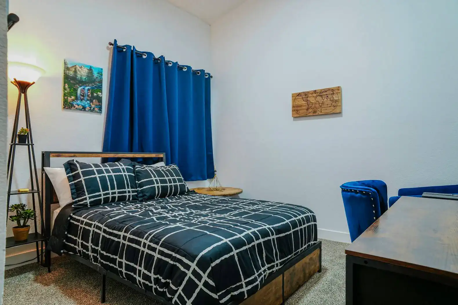 Cozy guest bedroom with a black and white checkered bedspread and blue curtains