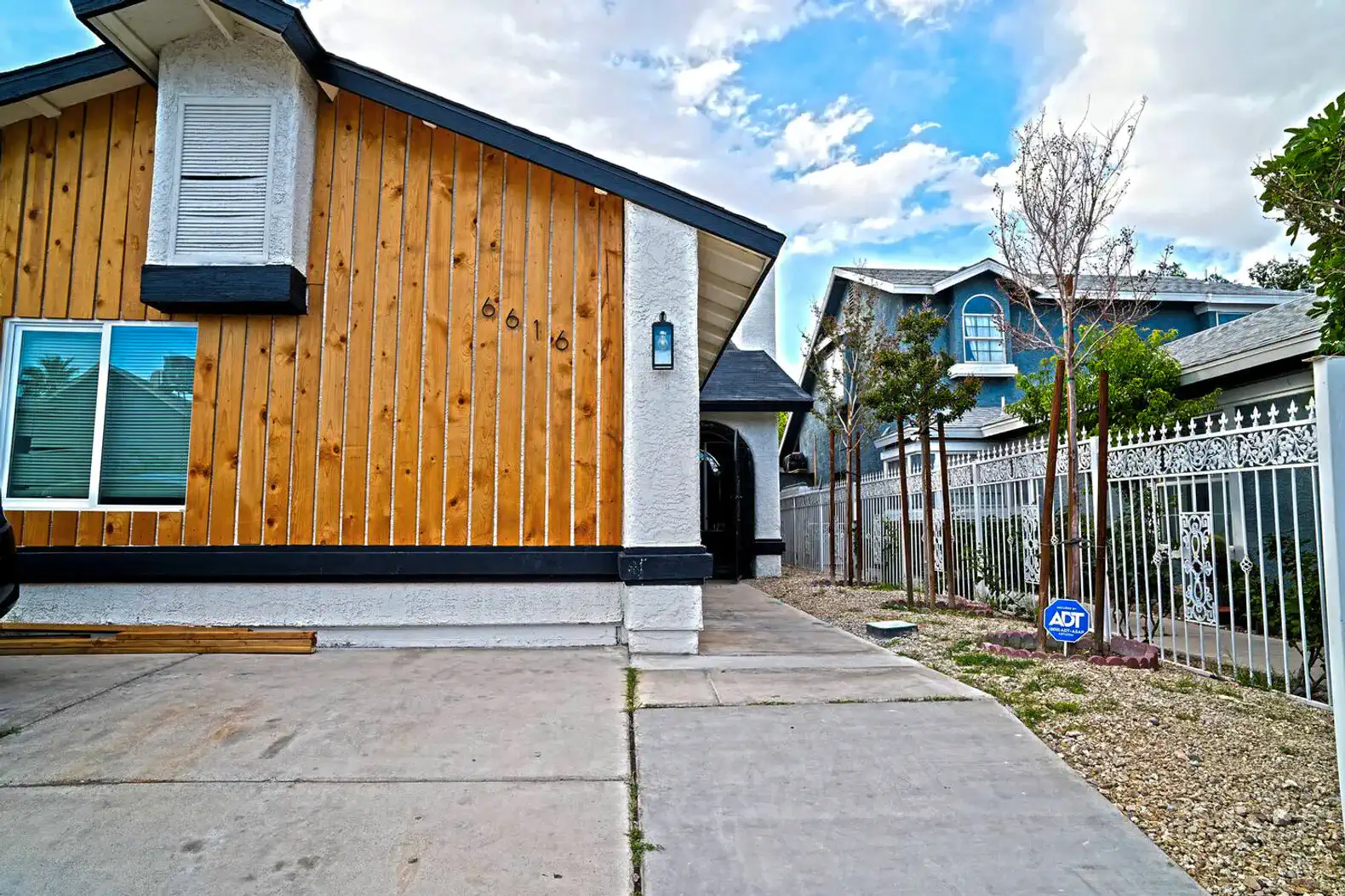Exterior view of the house showcasing wooden siding and driveway