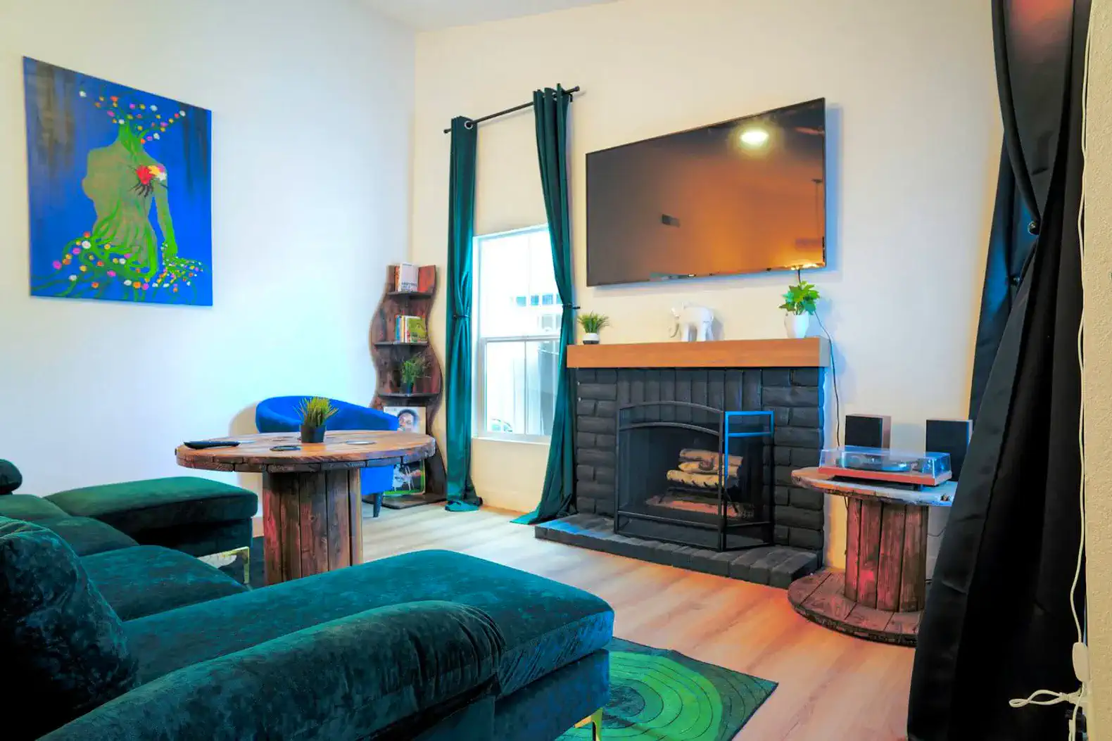 Cozy living room with a fireplace, colorful artwork, and comfortable seating