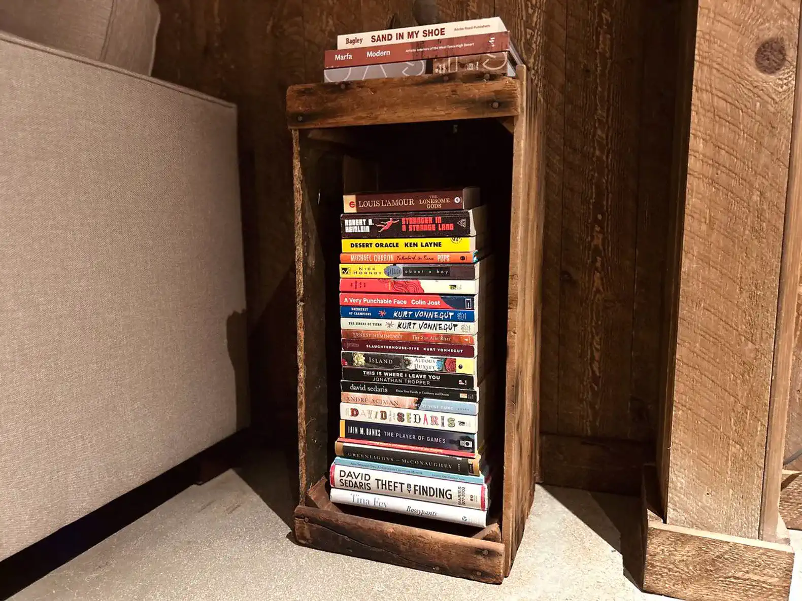 Wooden bookshelf filled with various books in a cozy corner