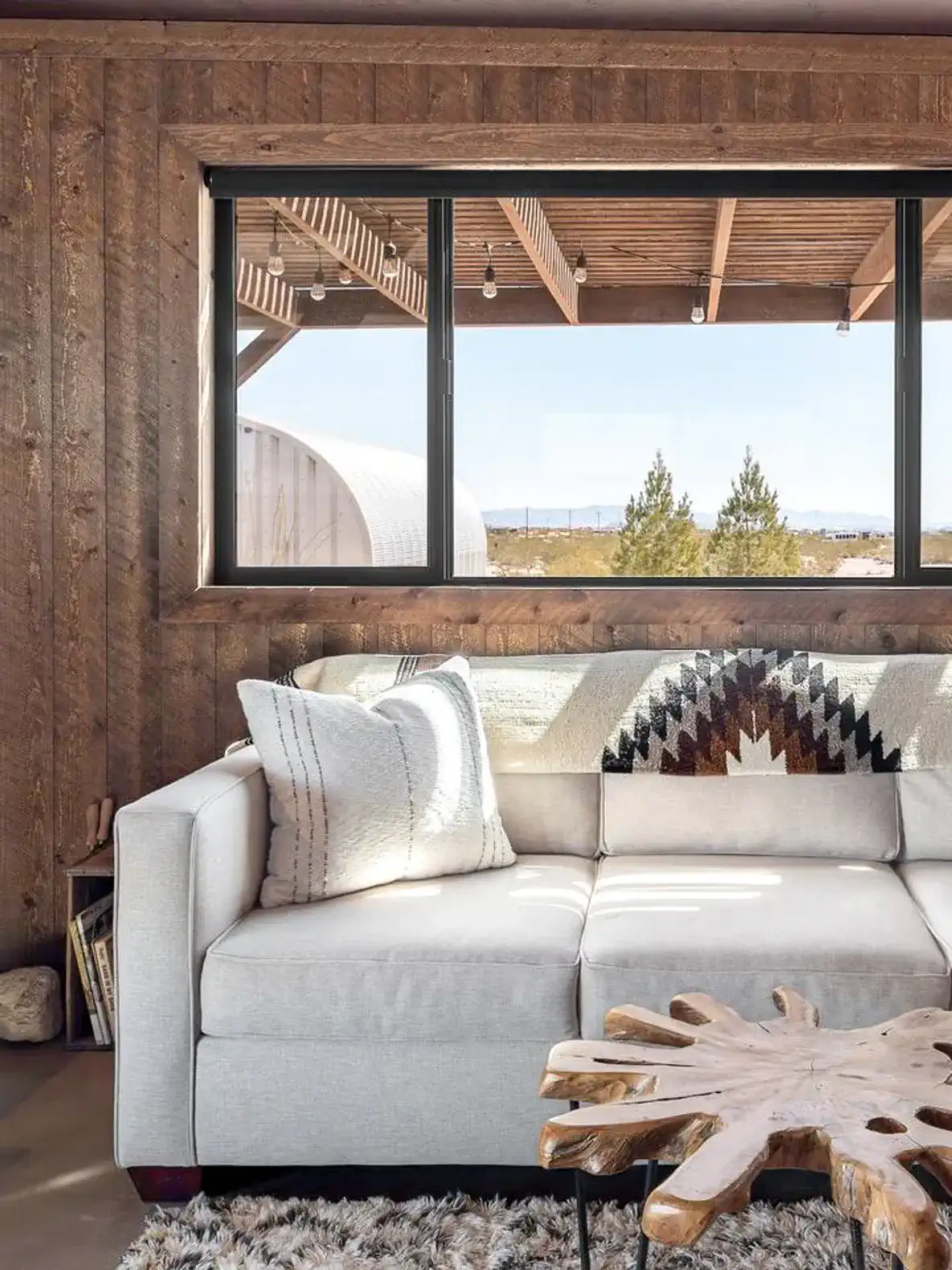 Cozy living room with a modern sofa and a view of the outdoors through large windows