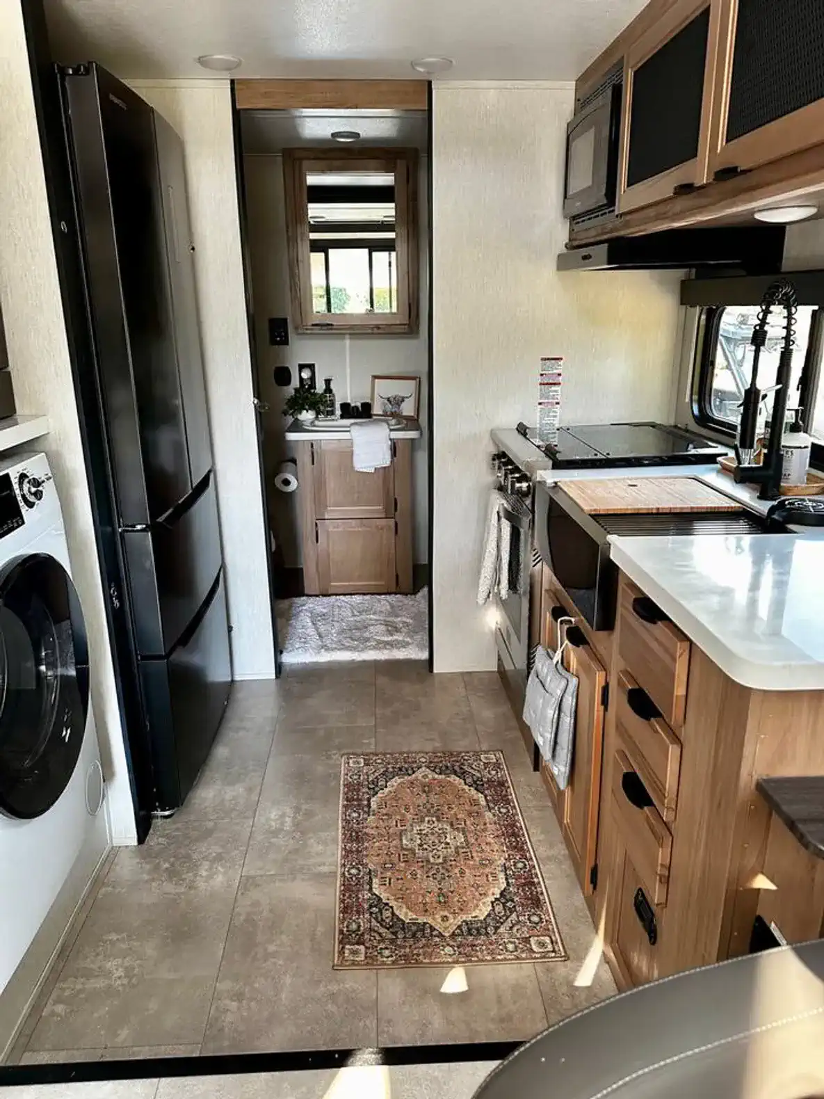 Modern kitchen with appliances, laundry area, and access to a bathroom