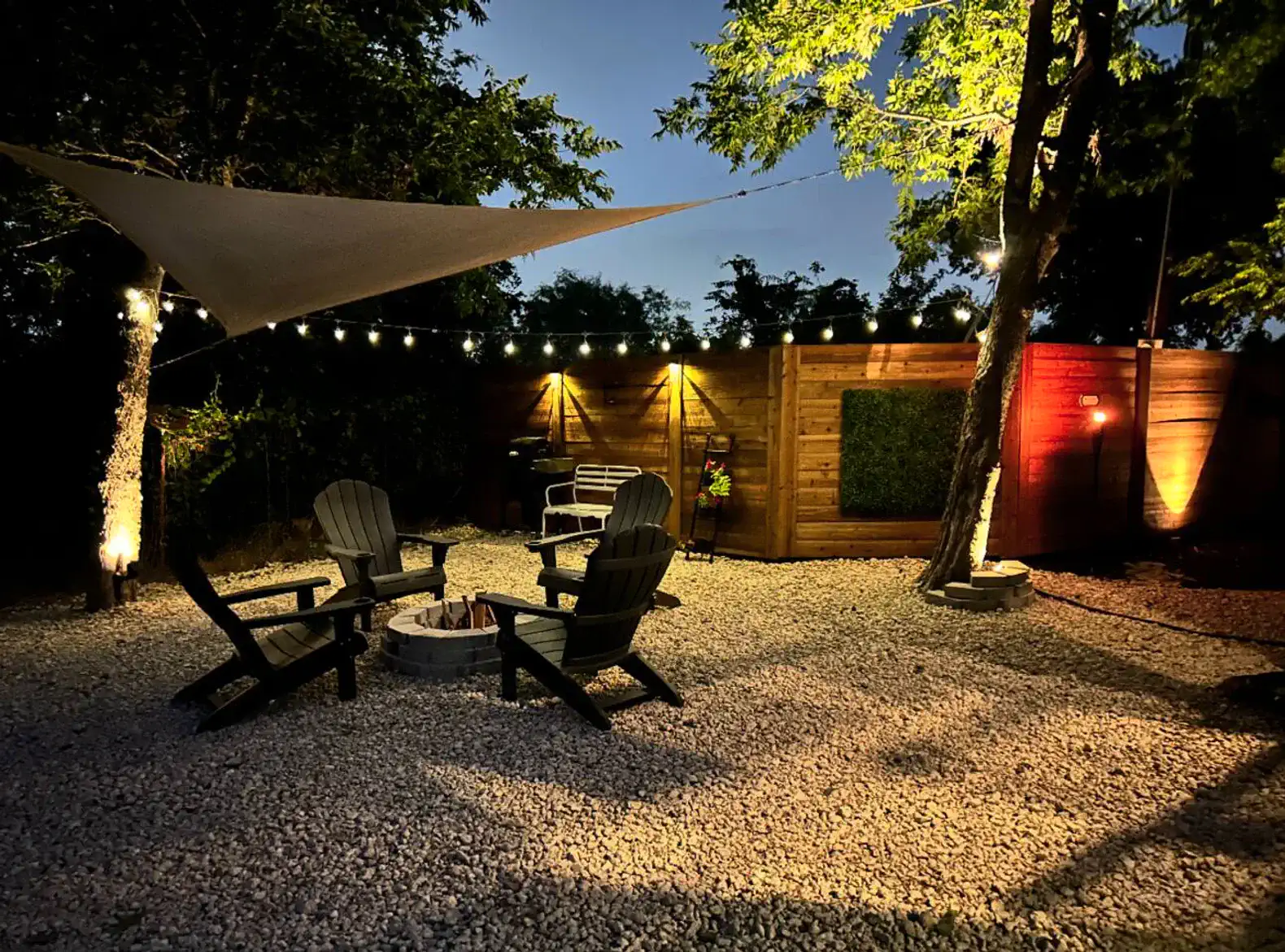 Cozy outdoor seating area with fire pit and string lights