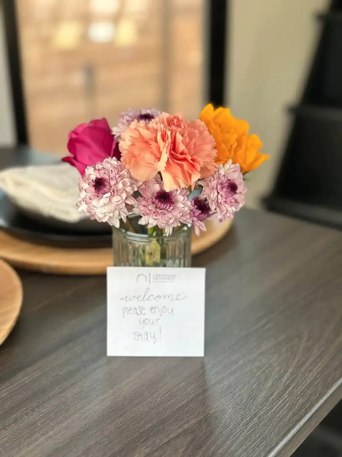 Colorful flower arrangement with a welcome note on a table