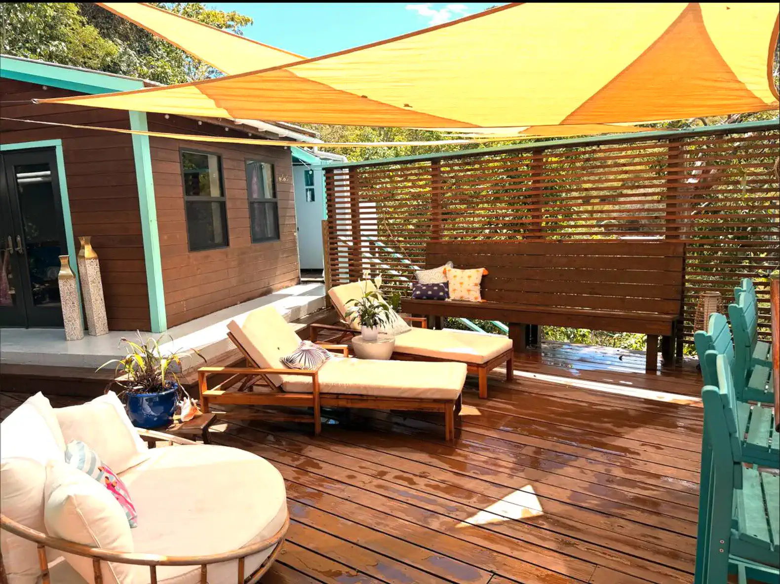 Spacious outdoor deck with lounge chairs and vibrant shade sails