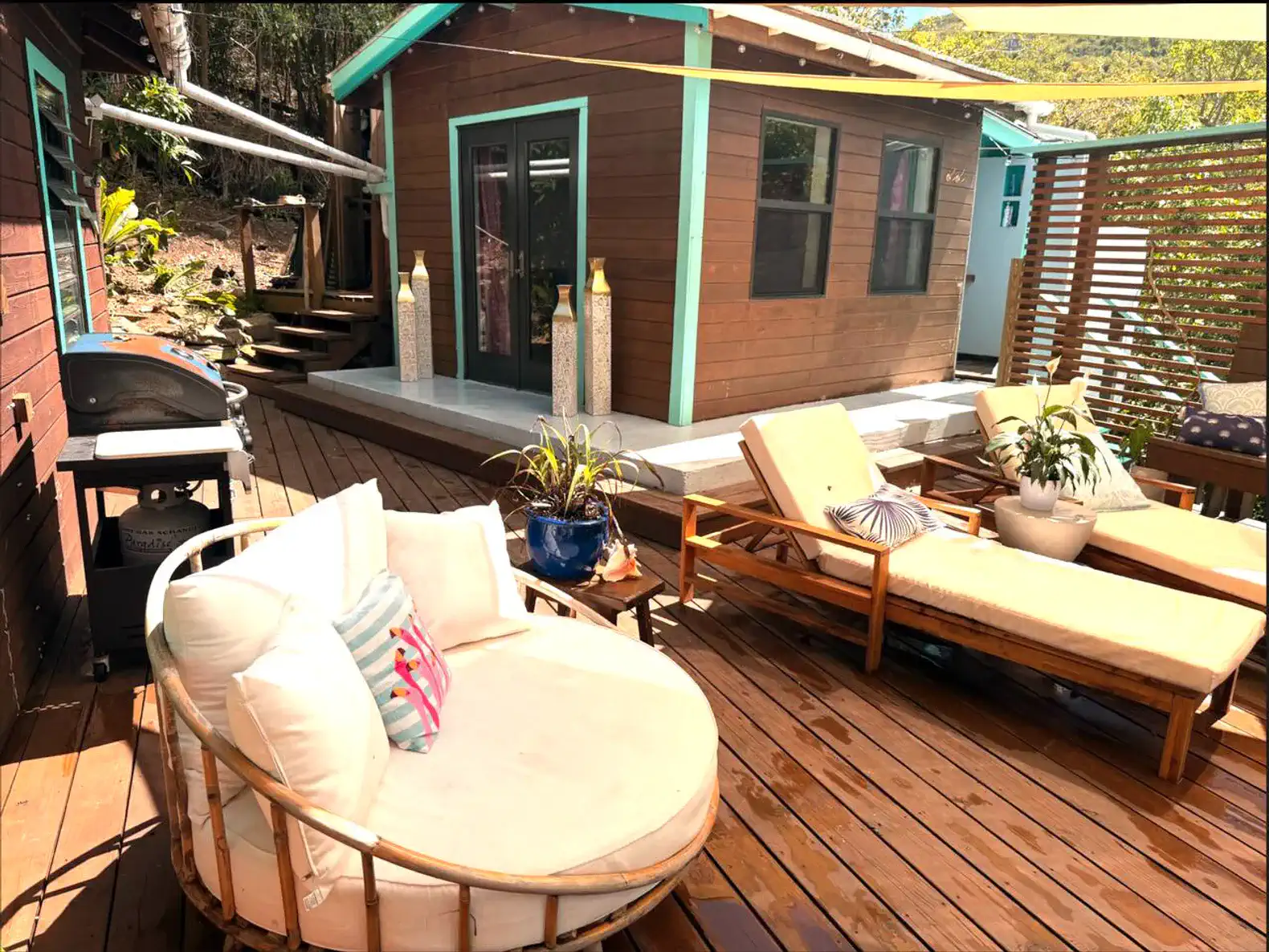 Cozy outdoor seating area with loungers and a view of the wooden deck