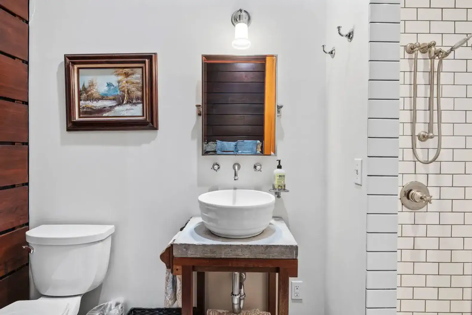 Stylish bathroom featuring a modern sink, wooden accents, and a tiled shower