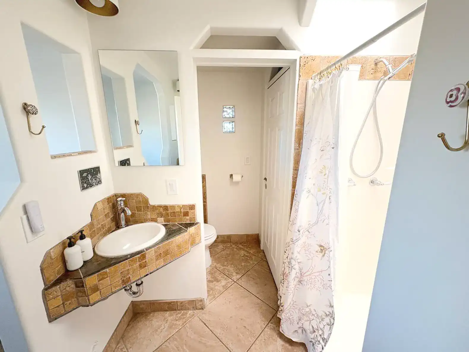 Bright bathroom featuring a sink with a stone countertop and a walk-in shower