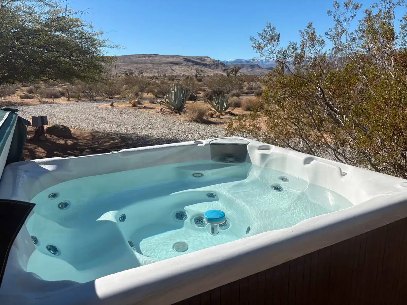 Hot tub with scenic desert views and surrounding vegetation