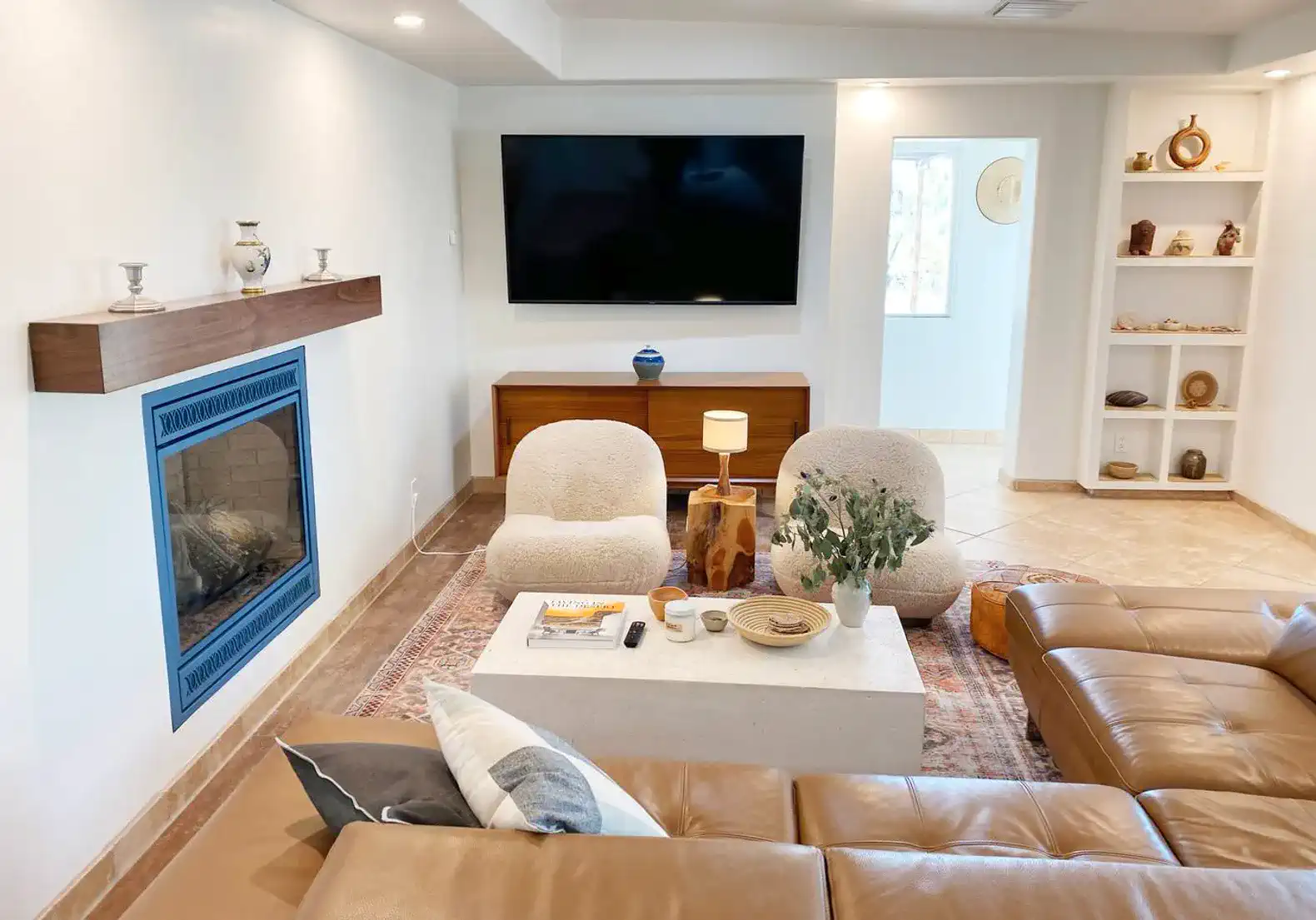 Cozy living room with modern furniture, fireplace, and large TV