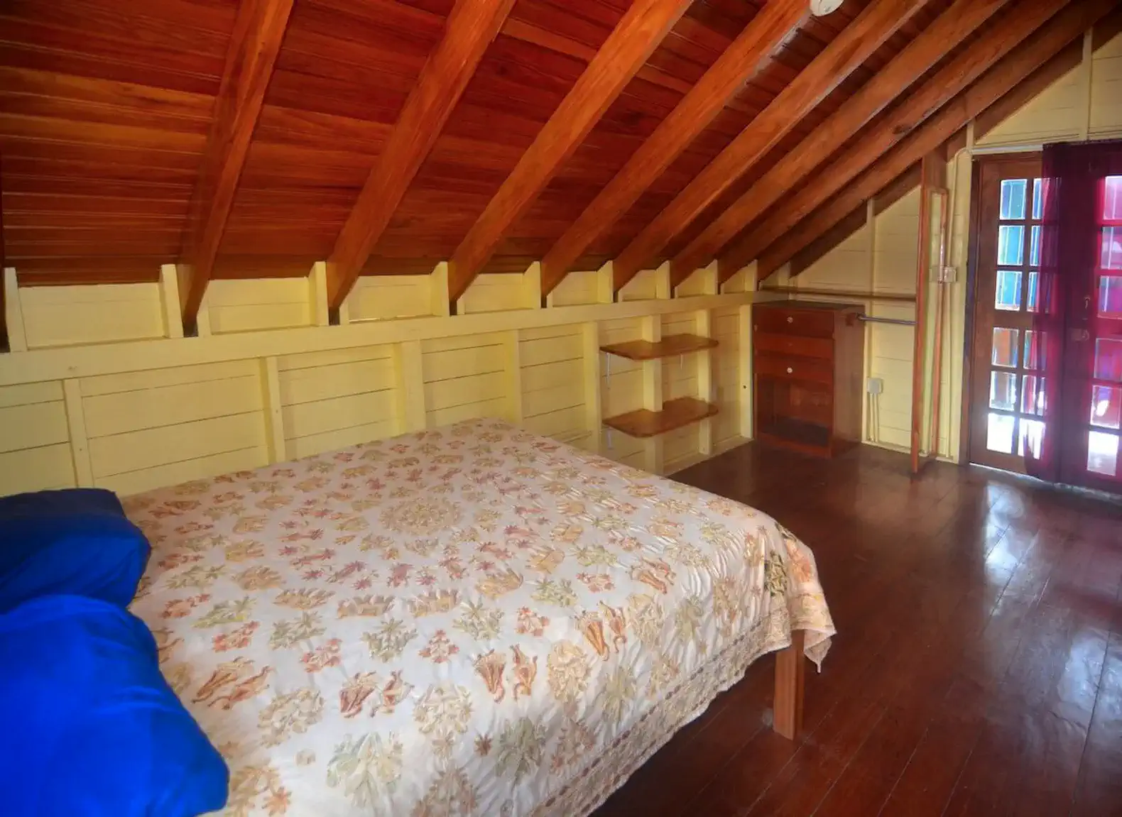 Cozy bedroom with wooden beams and a floral bedspread
