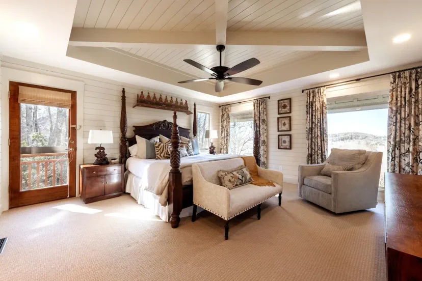King-Poster-Suite mit Decken mit Kassetten, Zugang zu einem privaten Balkon und atemberaubenden Bergblicken — das Hauptschlafzimmer im High House bietet luxuriösen Komfort einer Berghütte in der Nähe von Highlands & Cashiers, NC.