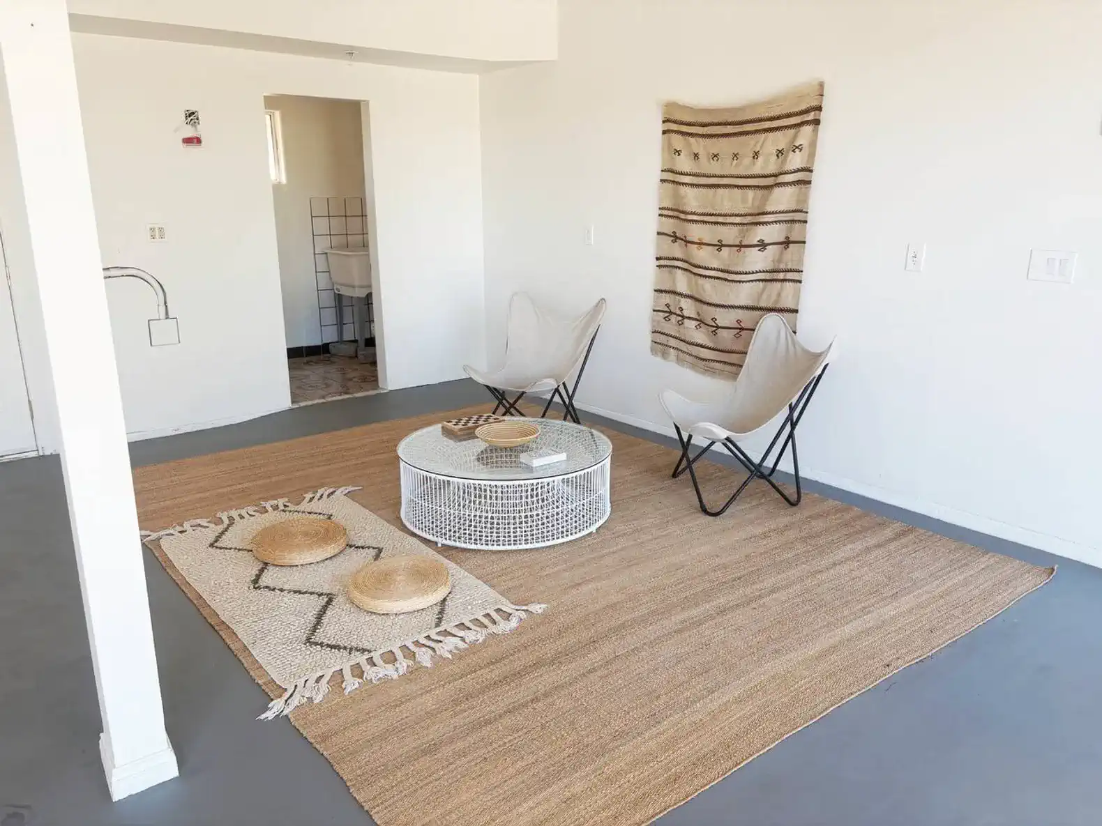 Cozy living area with two chairs, a round coffee table, and a woven rug