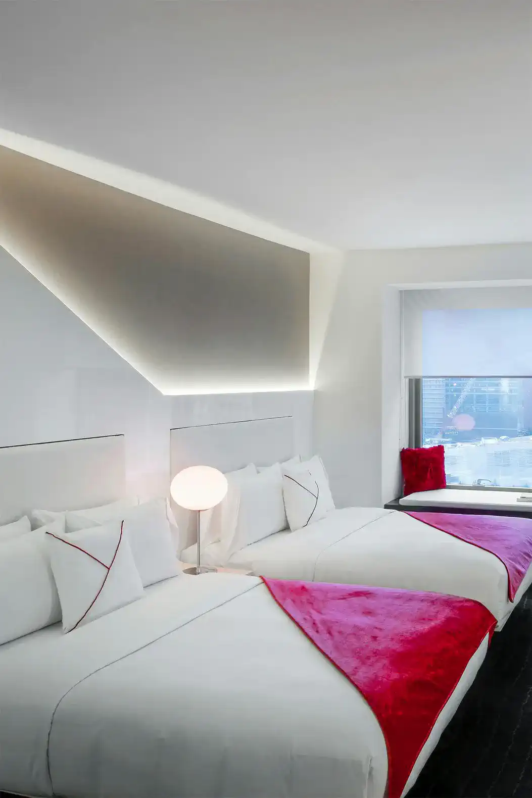 Stylish guest room with two beds, modern decor, and city view