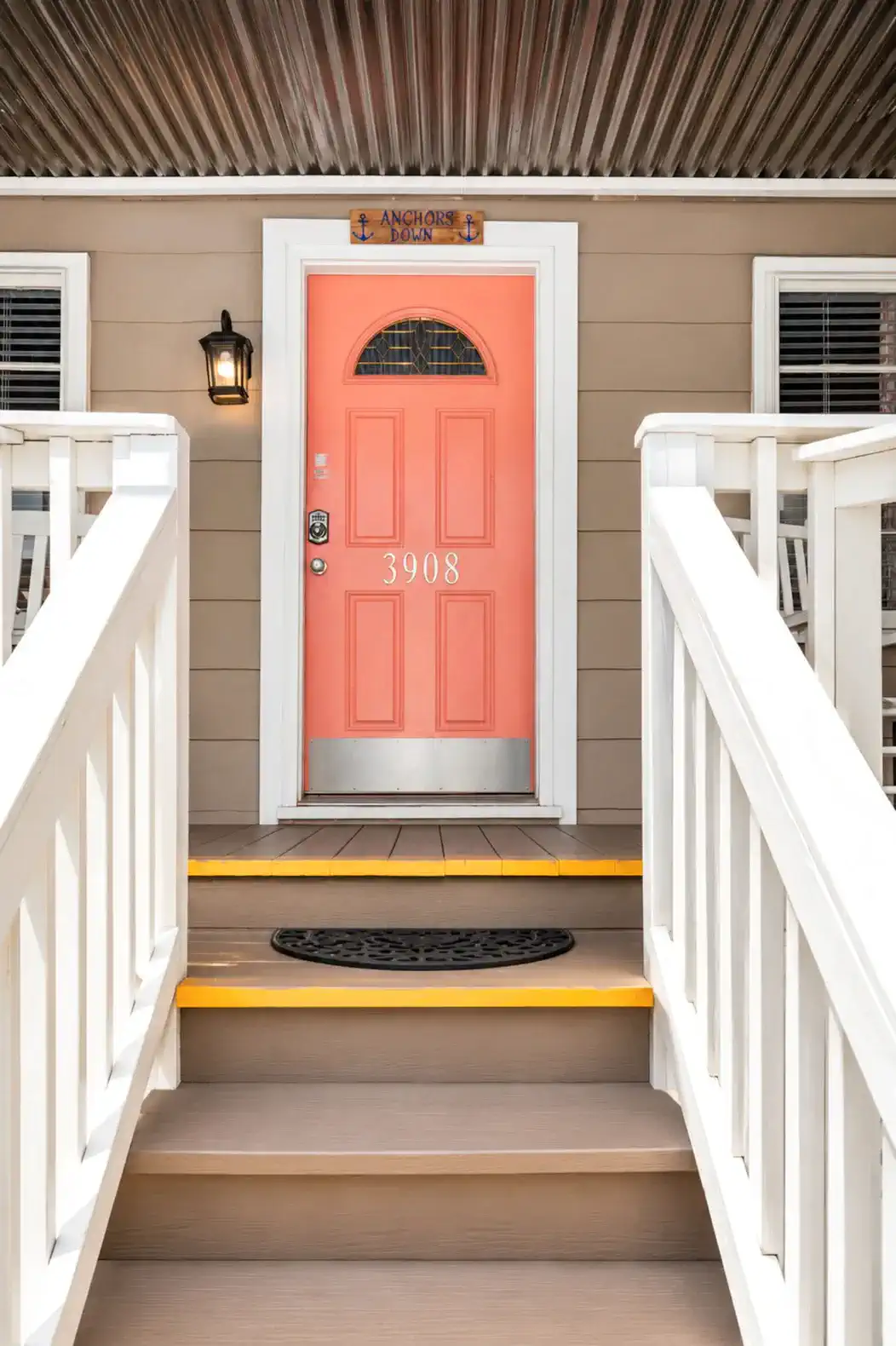 Bright coral front door with decorative window and welcoming steps