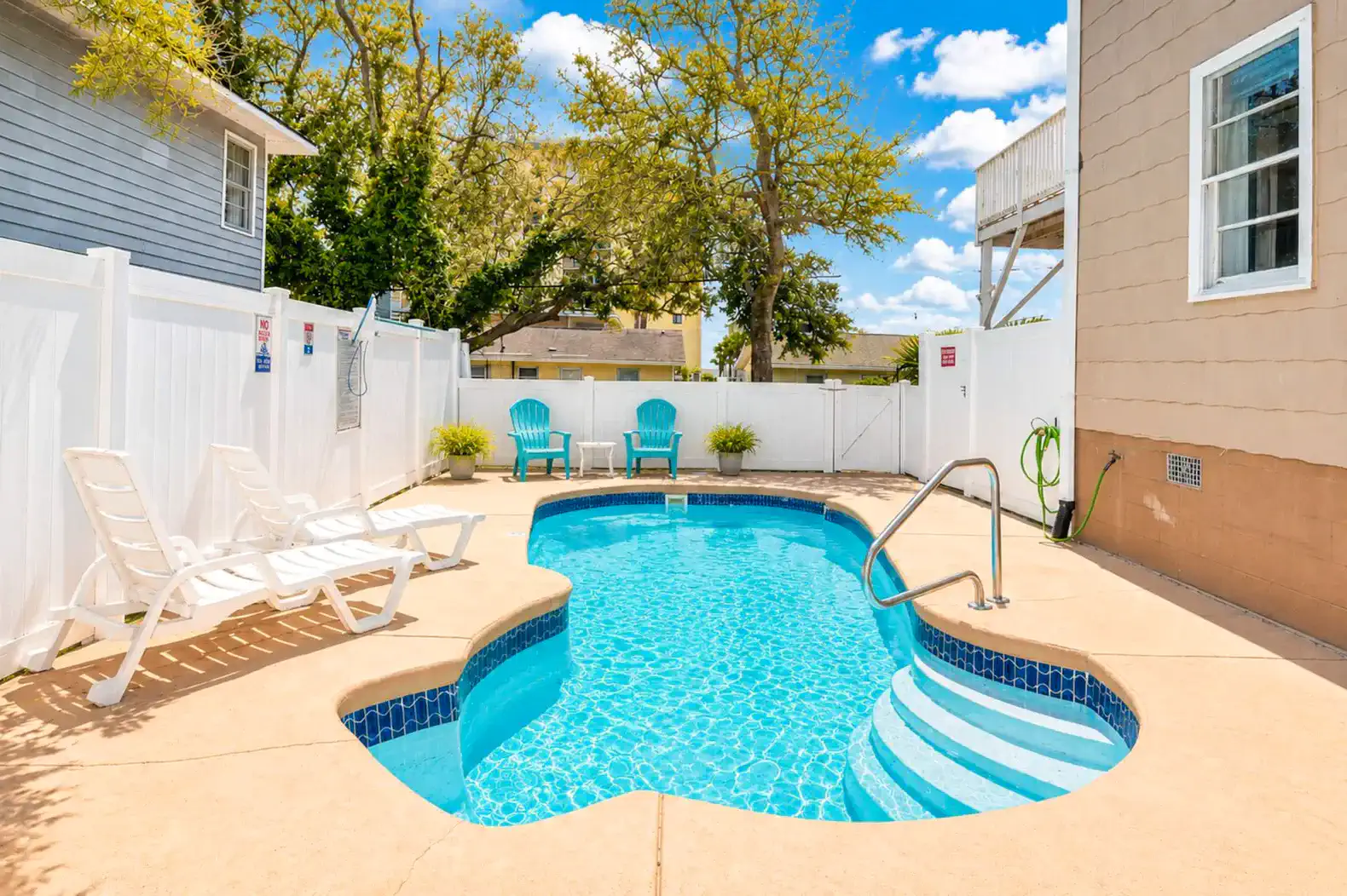 Private pool surrounded by lounge chairs and greenery
