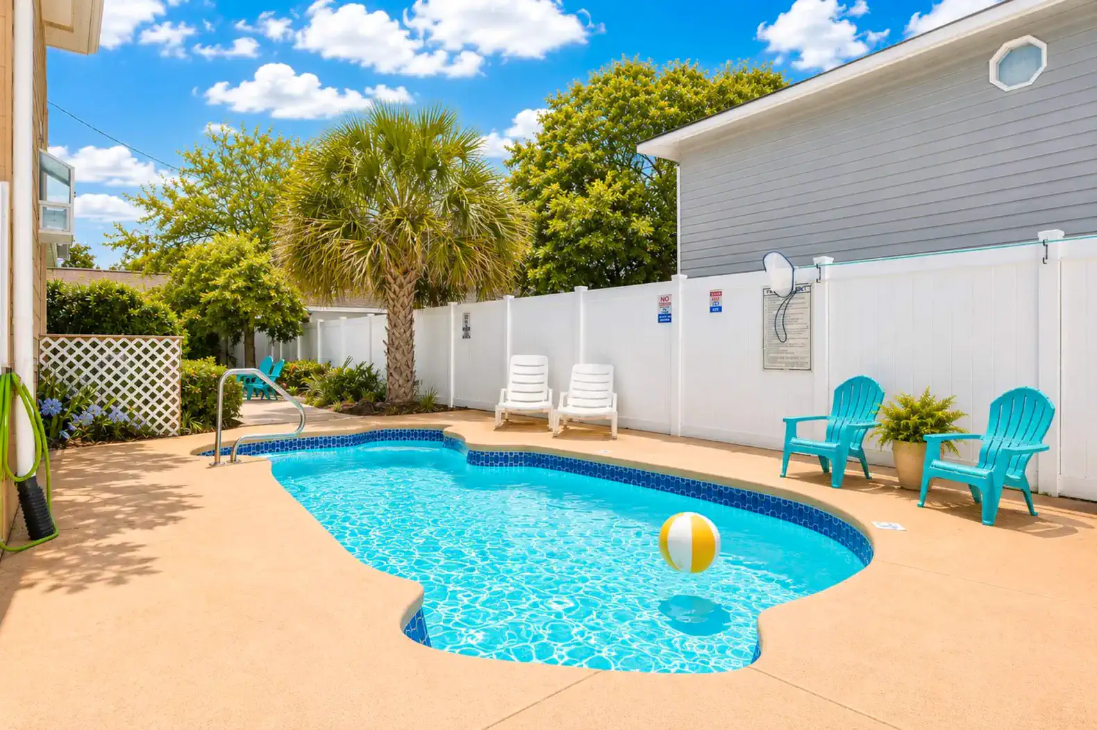 Bright pool area with lounge chairs and palm trees, perfect for relaxation