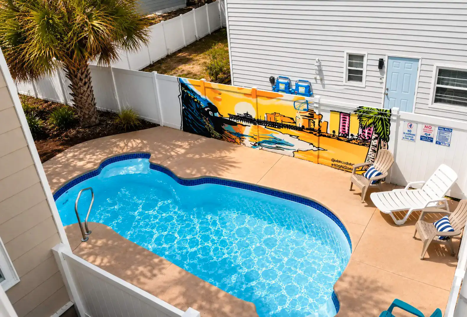 Private pool area with colorful mural and lounge chairs
