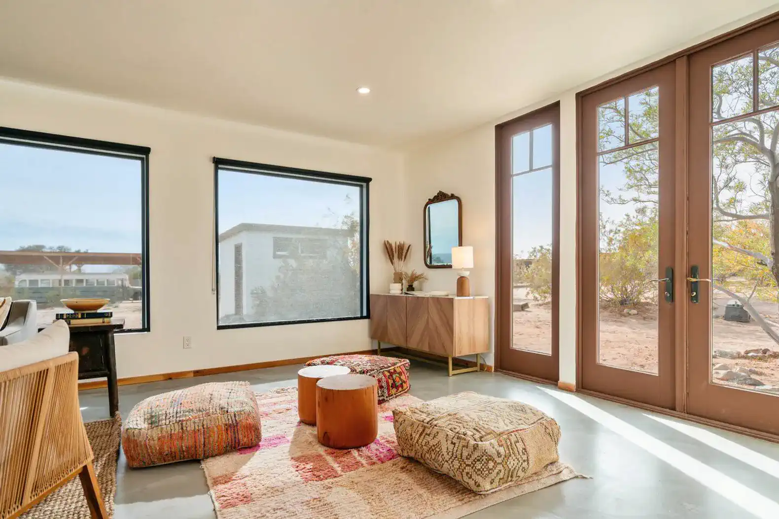 Cozy living room with large windows, colorful rugs, and modern decor
