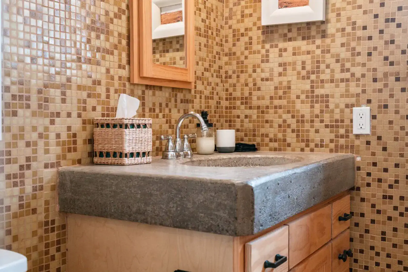 Stylish bathroom with mosaic tile walls and a concrete sink