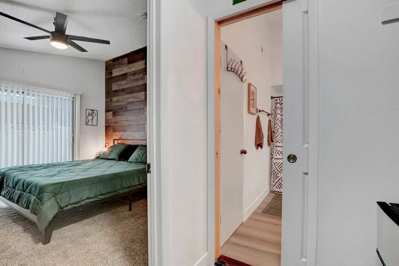Cozy bedroom with green bedding and wooden accent wall