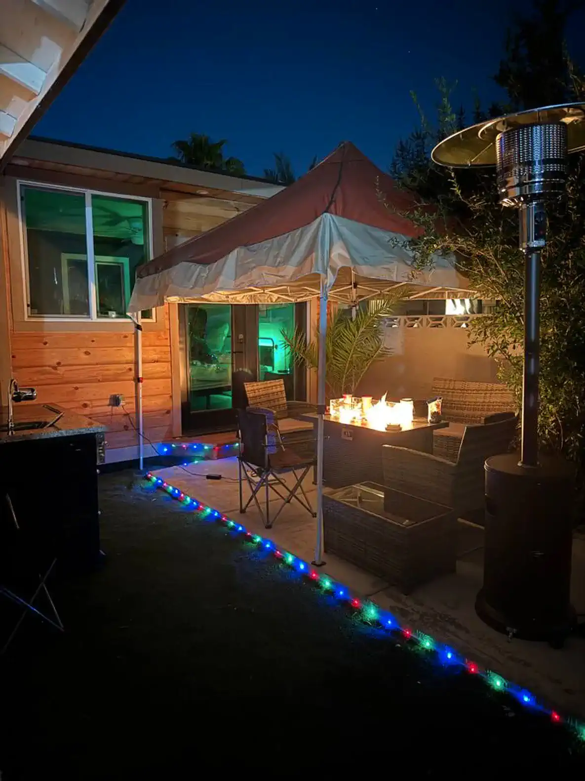 Private backyard with fireplace, bbq, furniture, and lights