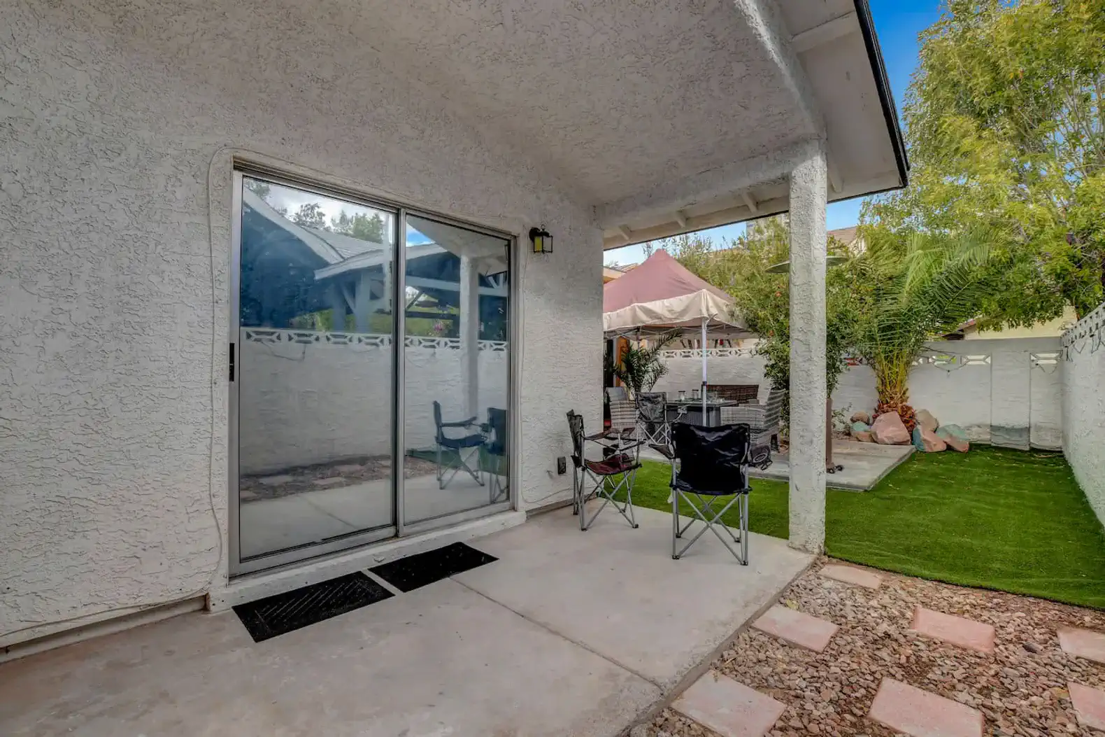 Outdoor seating area with chairs and artificial grass