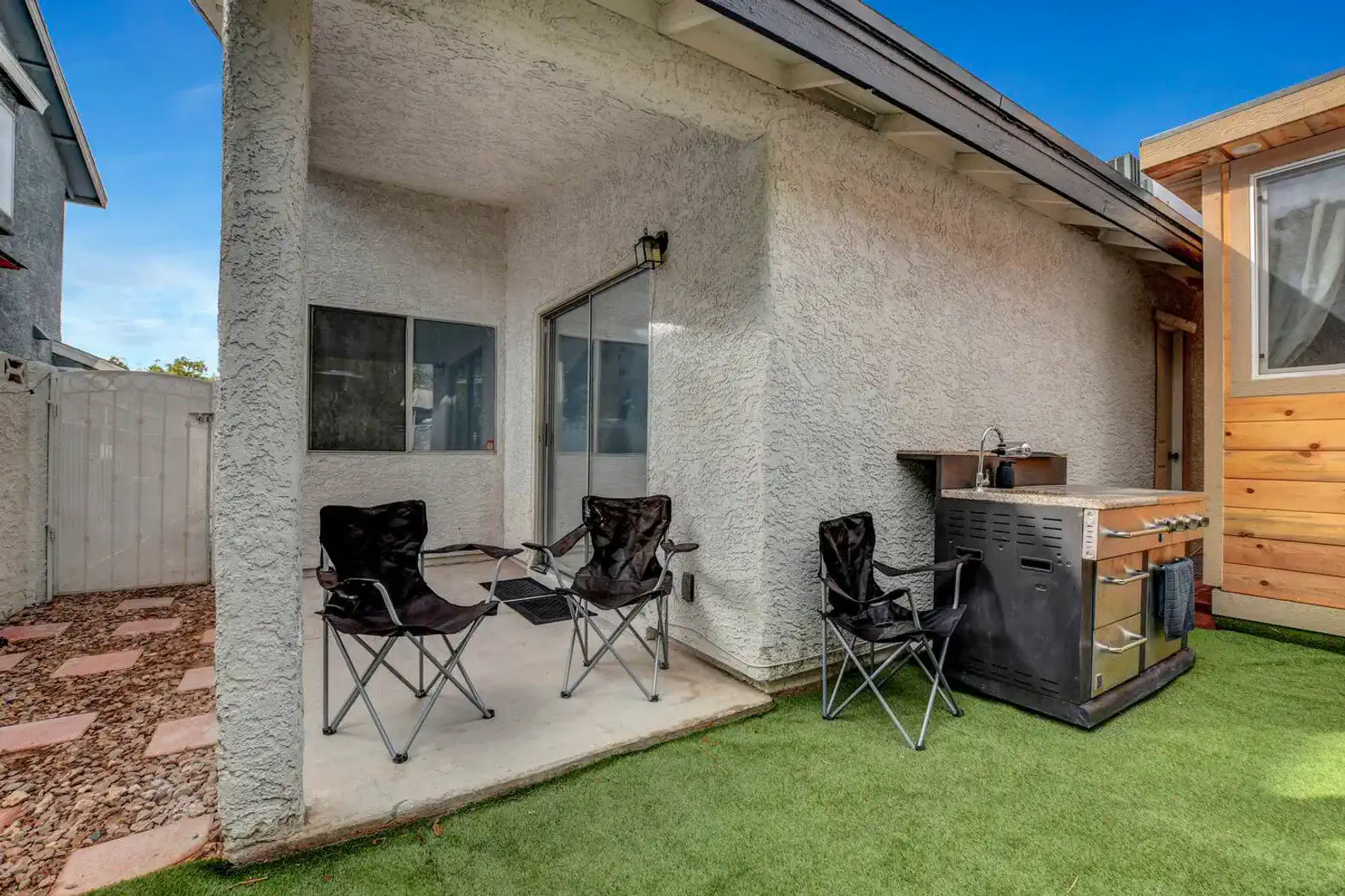 Cozy outdoor seating area with grill and artificial grass
