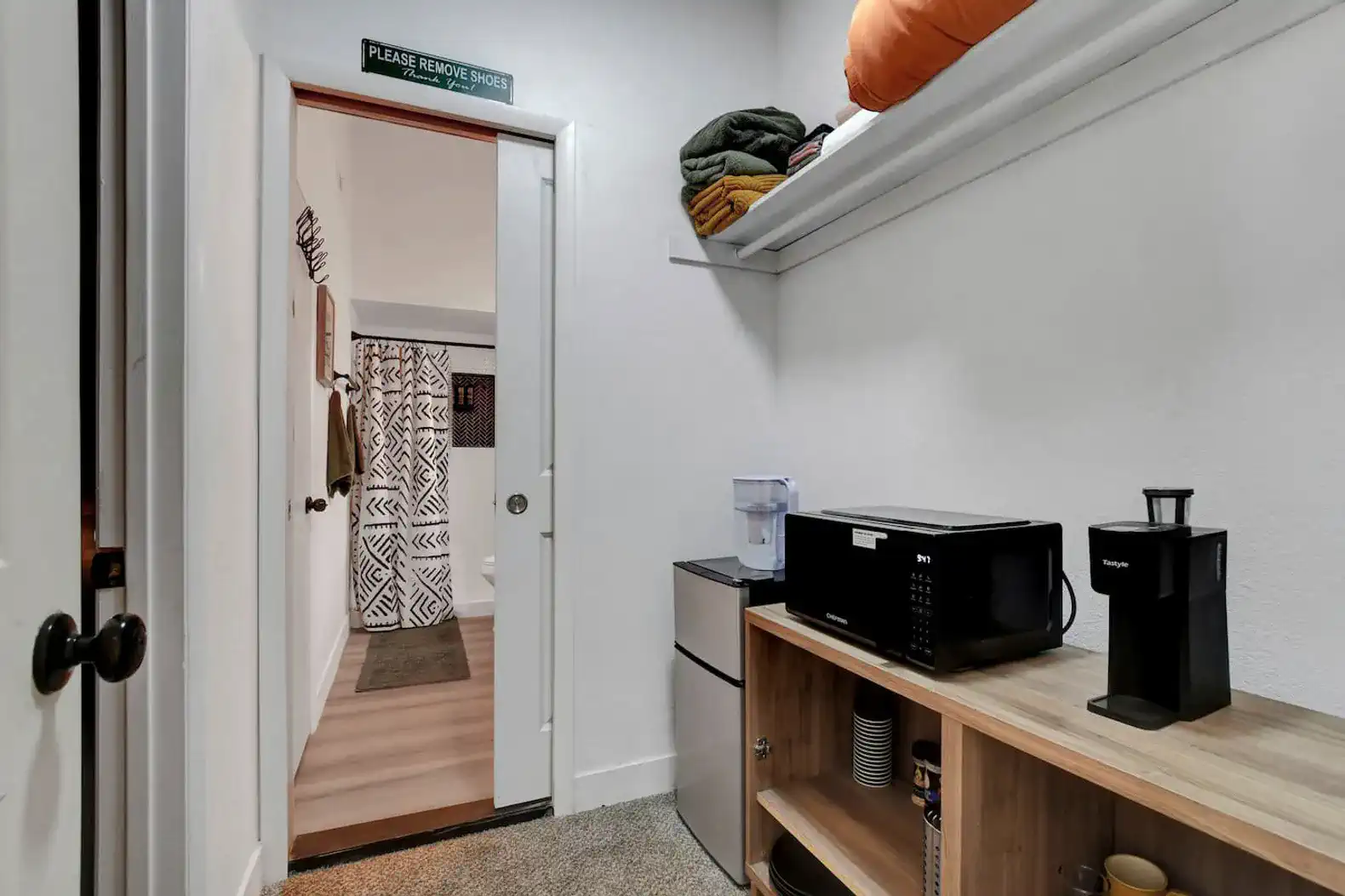 Cozy nook with microwave, coffee maker, and storage shelves