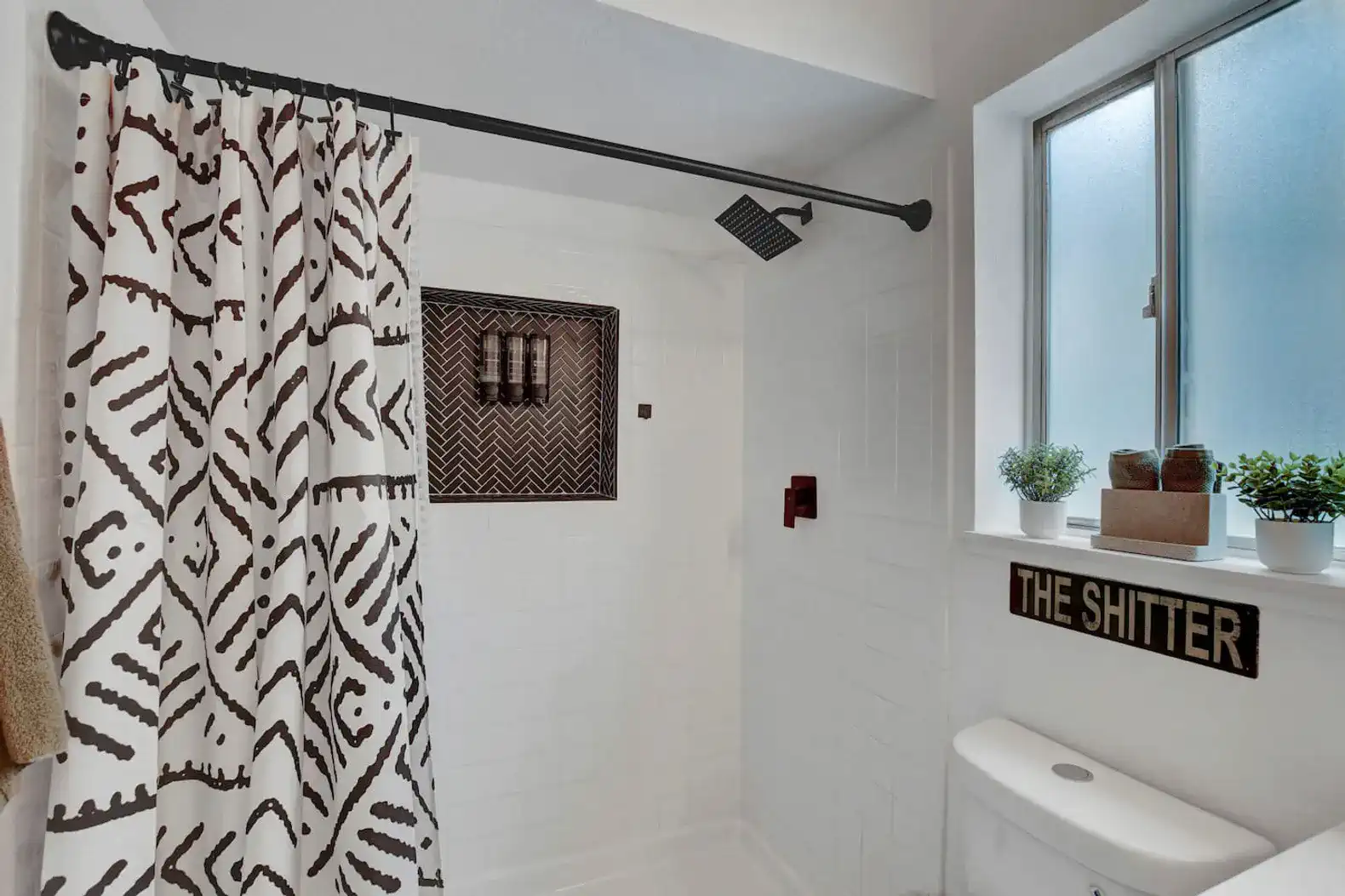 Bright and modern bathroom with a shower, decorative curtain, and window