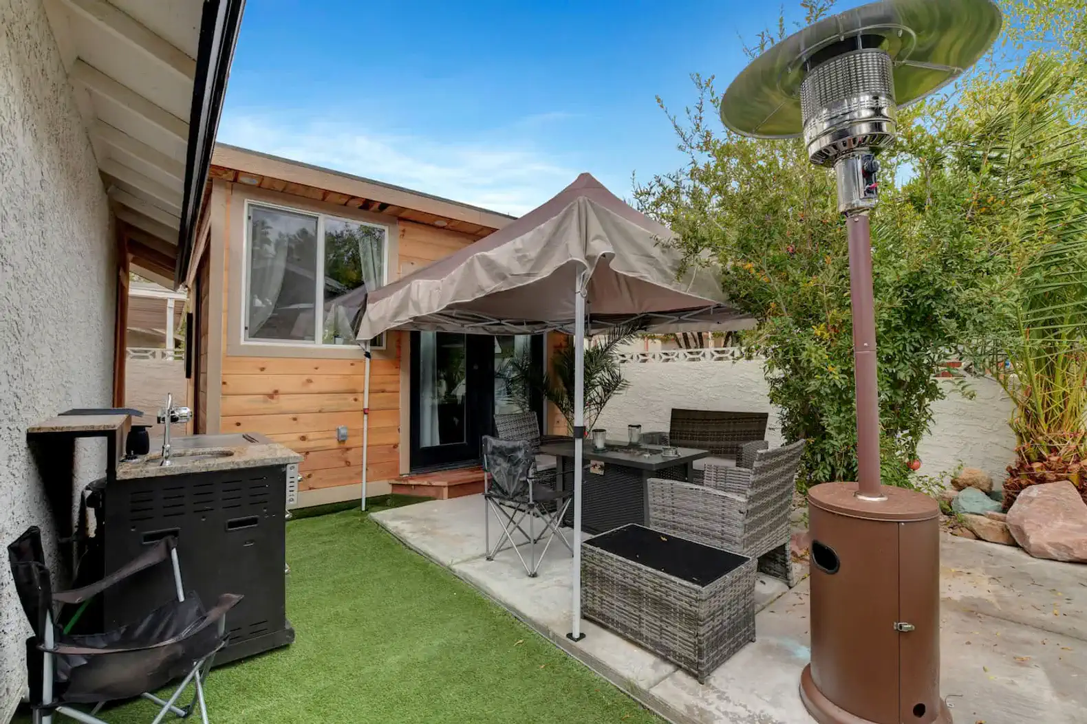 Cozy outdoor seating area with a canopy and heater in a private backyard