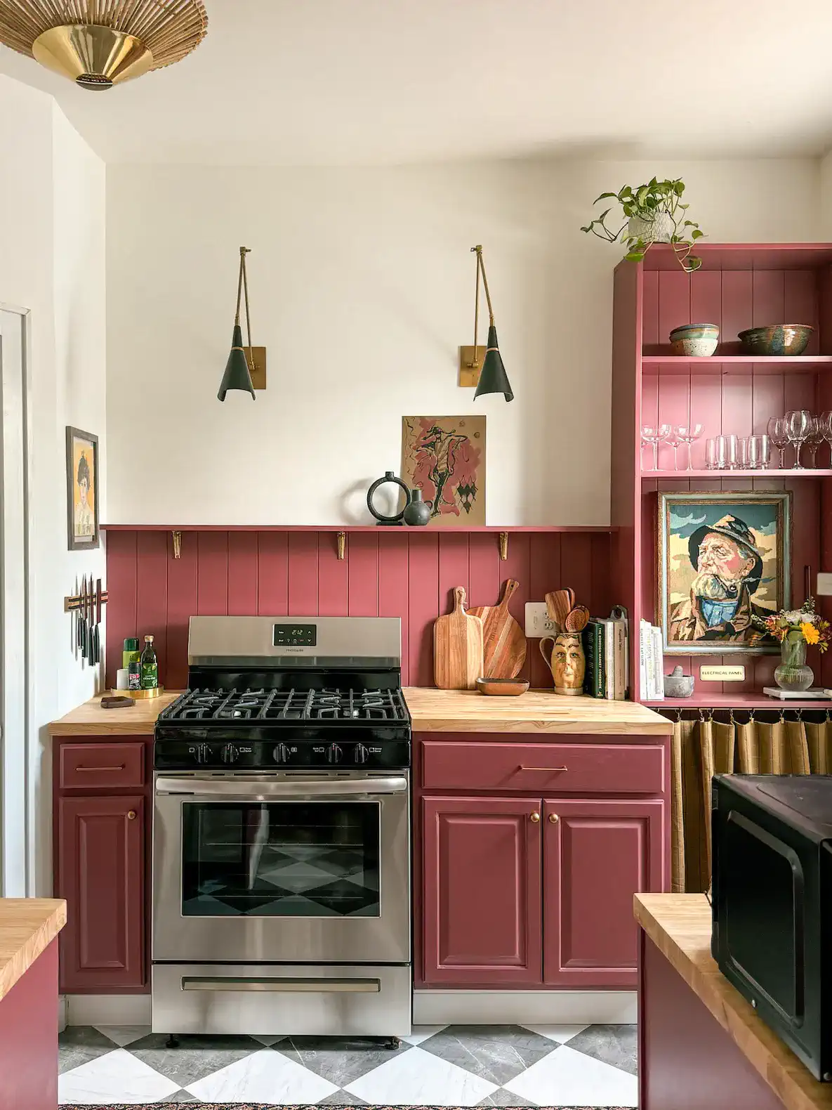 Charming kitchen with burgundy cabinets, stainless steel stove, and wooden countertops