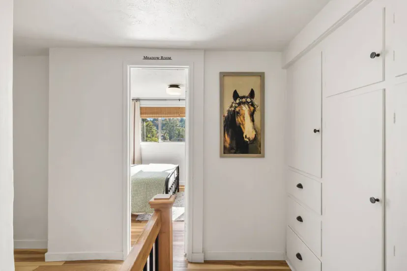Heller Flur, der zum Master Room führt, mit einem Pferdeporträt und eingebauten Stauraumschränken